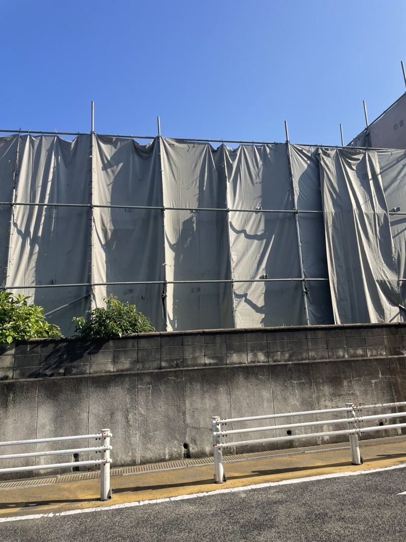 足場を組み、養生シートで建物を囲った様子